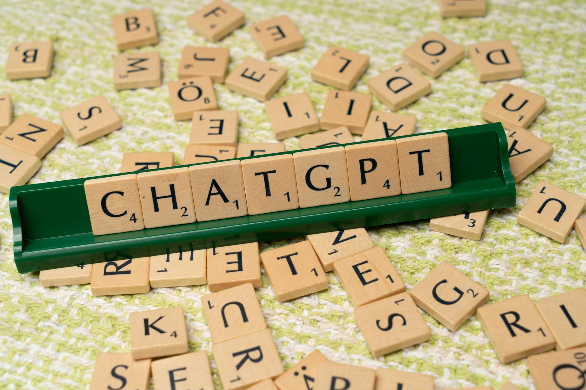 A photograph of scrabble tiles spelling Chat GPT